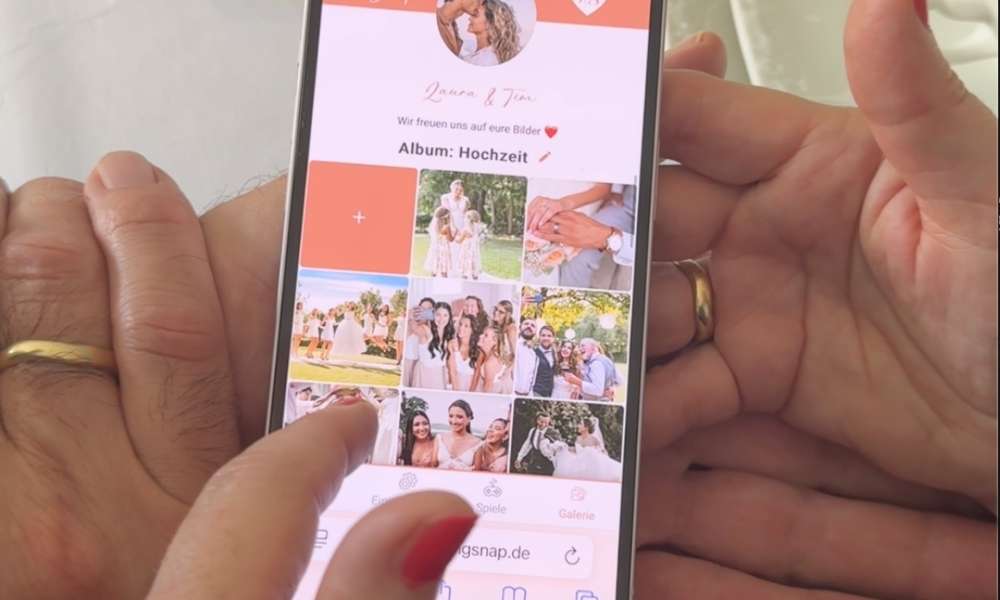 Nahaufnahme eines Smartphones, das die digitale Fotogalerie eines Brautpaares zeigt. Nach dem Scannen des Hochzeit QR-Codes können Gäste hier ihre hochgeladenen Bilder in einem gemeinsamen Online-Album betrachten.